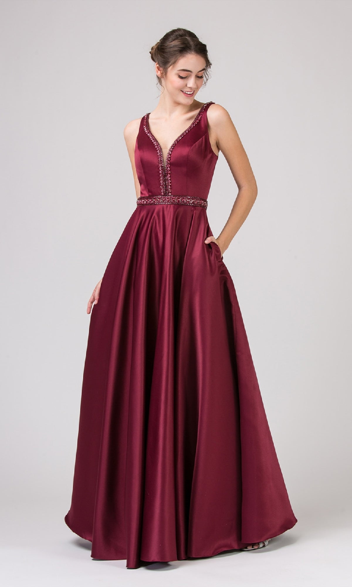 A woman models the Beaded-Waist Long Satin Prom Dress: Eureka 9010—a sleeveless, deep red gown with a V-neckline, beaded waist, and full-length skirt—against a plain light background.
